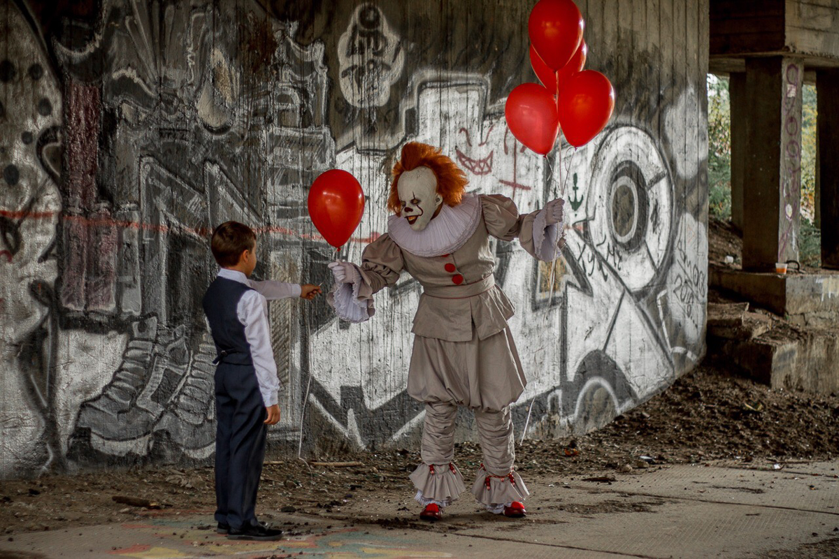 Люди выходят с показа фильма «ОНО» и видят самого настоящего Пеннивайза, который прыгает, злобно хихикает и протягивает красный шар, готовясь откусить руку...