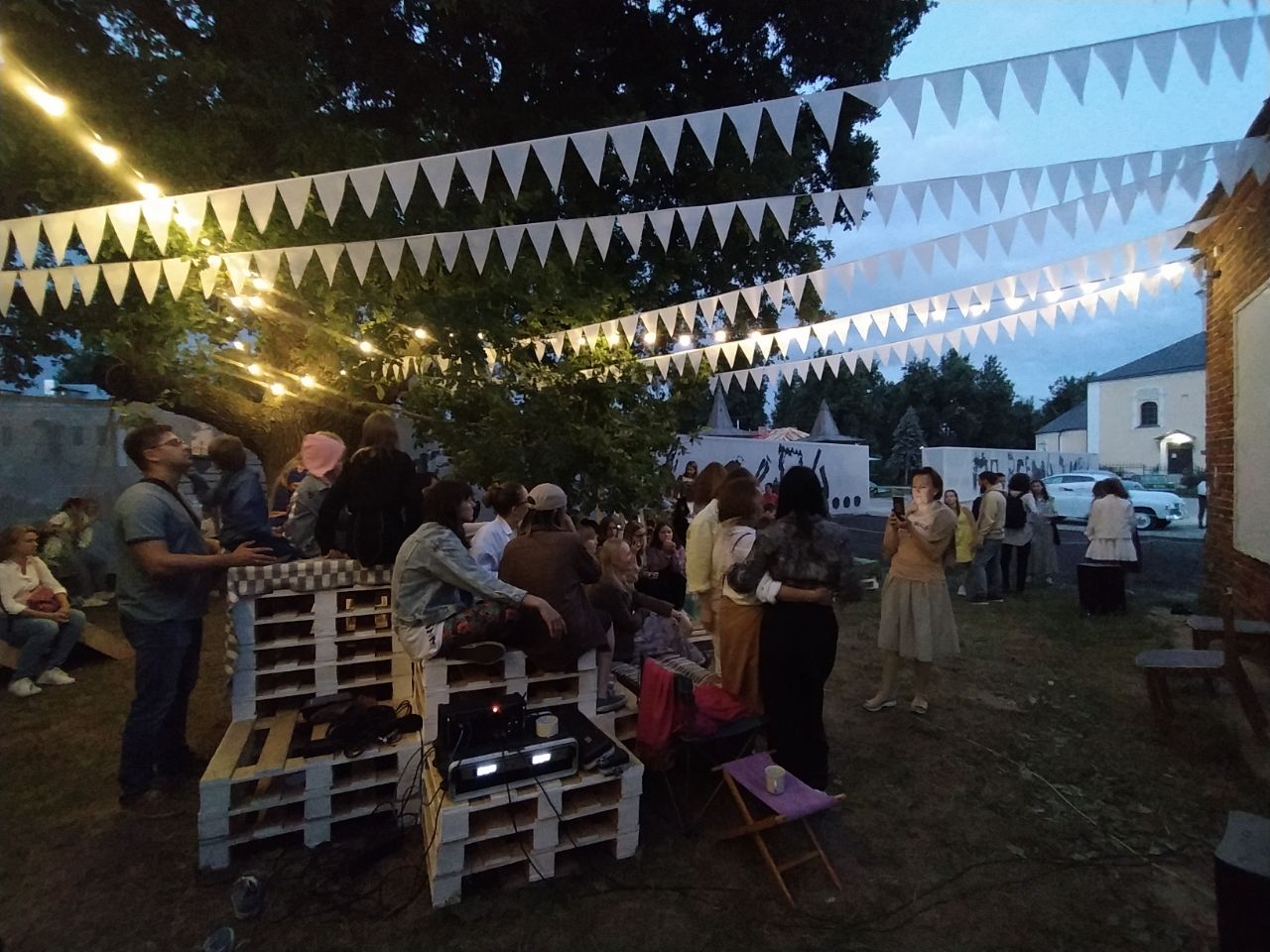 В Суздале появилось новое место для семейного отдыха. Маленькие жители города при поддержке команды энтузиастов сами разработали проект и создали дворик на Кремлевской улице! Теперь там устраивают открытые кинопоказы, пьют чай из самовара и наслаждаются летом под древним дубом.