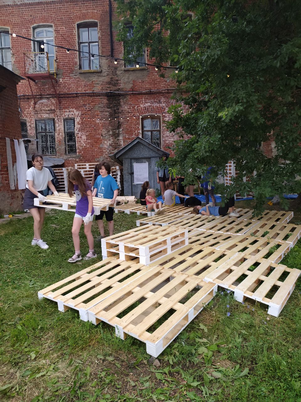 В Суздале появилось новое место для семейного отдыха. Маленькие жители города при поддержке команды энтузиастов сами разработали проект и создали дворик на Кремлевской улице! Теперь там устраивают открытые кинопоказы, пьют чай из самовара и наслаждаются летом под древним дубом.