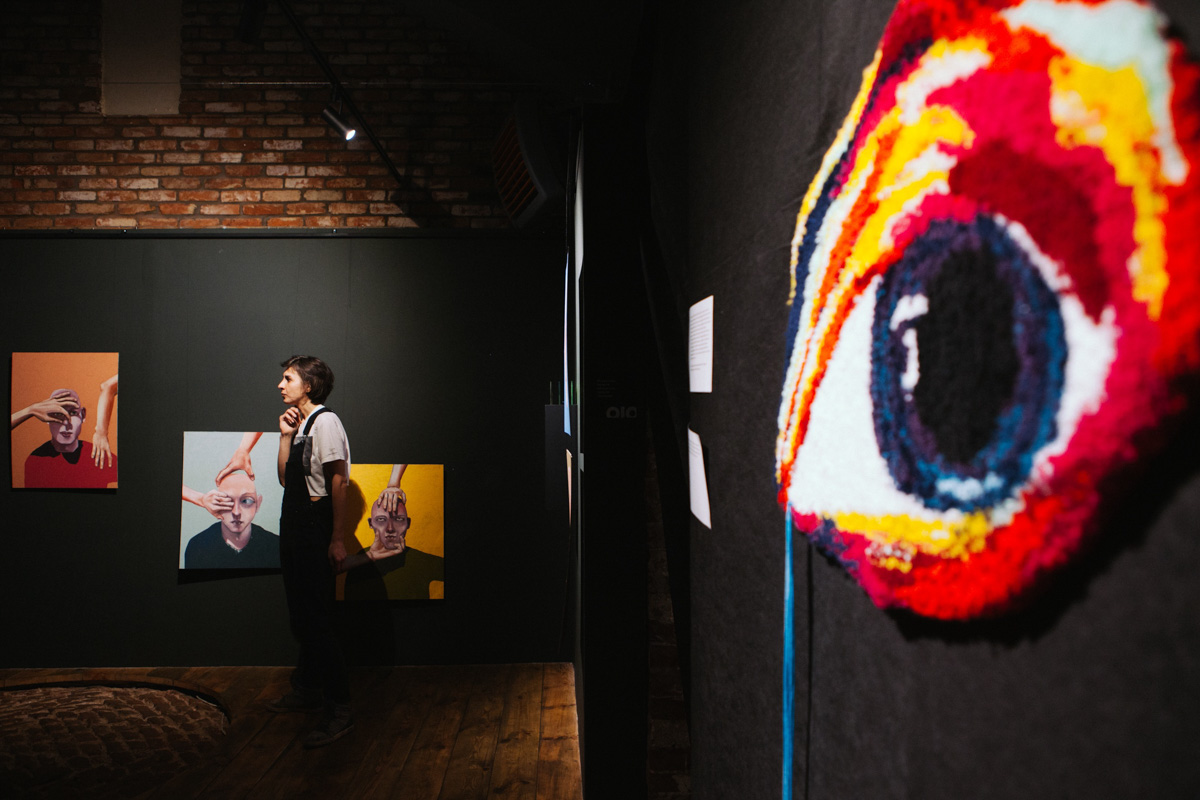 В выставочном зале ЦСК царит мягкий полумрак. Периодически сенсорные лампы, освещающие пространство, гаснут, и Валя Ивакина, художница-самоучка и хозяйка новой выставки, стартовавшей в начале апреля, топает ногой, чтобы свет вновь зажегся и осветил её картины, столь же красочные и яркие, сколь и вызывающие мурашки.