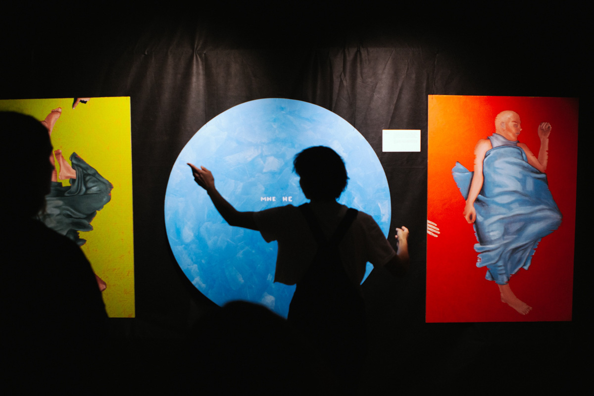 В выставочном зале ЦСК царит мягкий полумрак. Периодически сенсорные лампы, освещающие пространство, гаснут, и Валя Ивакина, художница-самоучка и хозяйка новой выставки, стартовавшей в начале апреля, топает ногой, чтобы свет вновь зажегся и осветил её картины, столь же красочные и яркие, сколь и вызывающие мурашки.