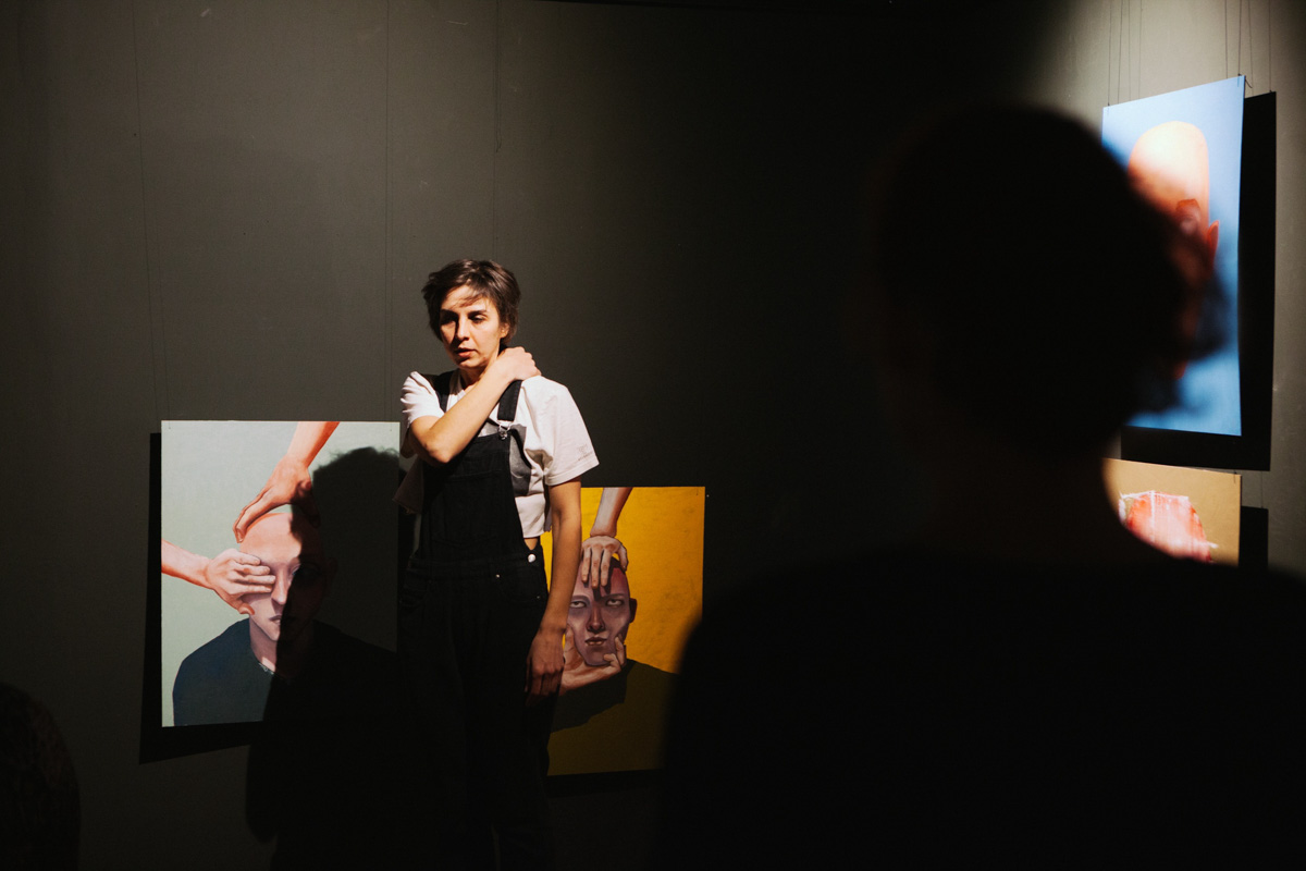 В выставочном зале ЦСК царит мягкий полумрак. Периодически сенсорные лампы, освещающие пространство, гаснут, и Валя Ивакина, художница-самоучка и хозяйка новой выставки, стартовавшей в начале апреля, топает ногой, чтобы свет вновь зажегся и осветил её картины, столь же красочные и яркие, сколь и вызывающие мурашки.