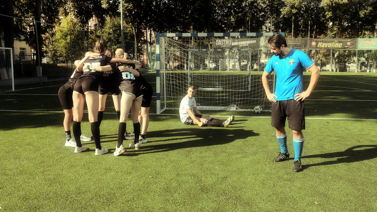 Яркие девушки бегут по футбольному полю: одна из них ловко ловит мяч в полёте, другая с очень серьёзным видом стоит на воротах… А мужчины, судя по невесёлым лицам, проиграли. Стоп, какие мужчины? Разве правила позволяют?.. Действительно, самые настоящие футболисты сразились в игре с владимирскими моделями.