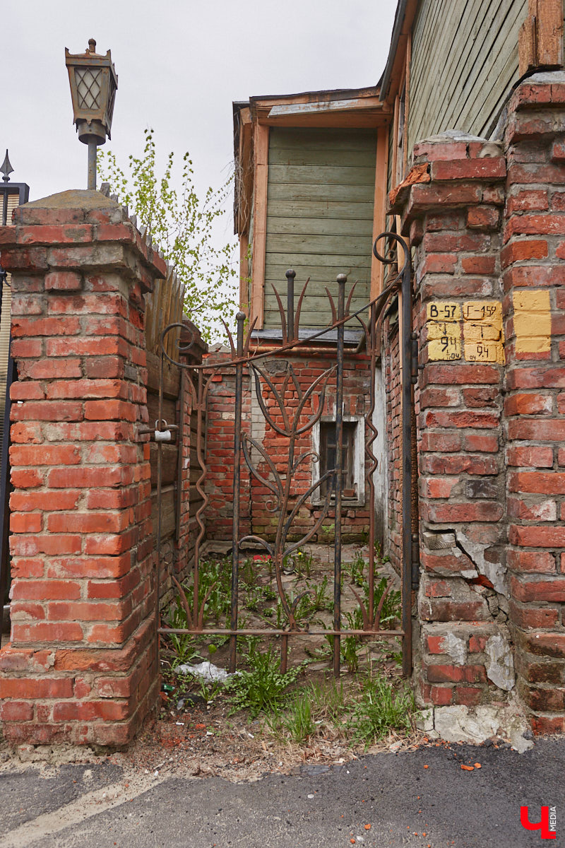 В начале Никитской улицы сразу бросается в глаза полукаменный дом № 2. В четном ряду своих собратьев он выделяется особой архитектурой, внушительным объемом, хорошо сохранившимися старинными воротами, наличниками и даже ставнями, что в исторической части Владимира сейчас большая редкость. А еще внимание привлекают две вывески на здании, знакомство с которыми вызывает множество вопросов.