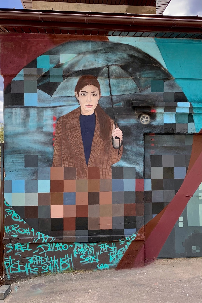 Известный во Владимире уличный художник Мишкин разукрасил серую стену постройки на территории популярного лофт-пространства. Так, на улице Сакко и Ванцетти появилось изображение девушки под зонтом. Что интересно, у нее есть реальный прототип.