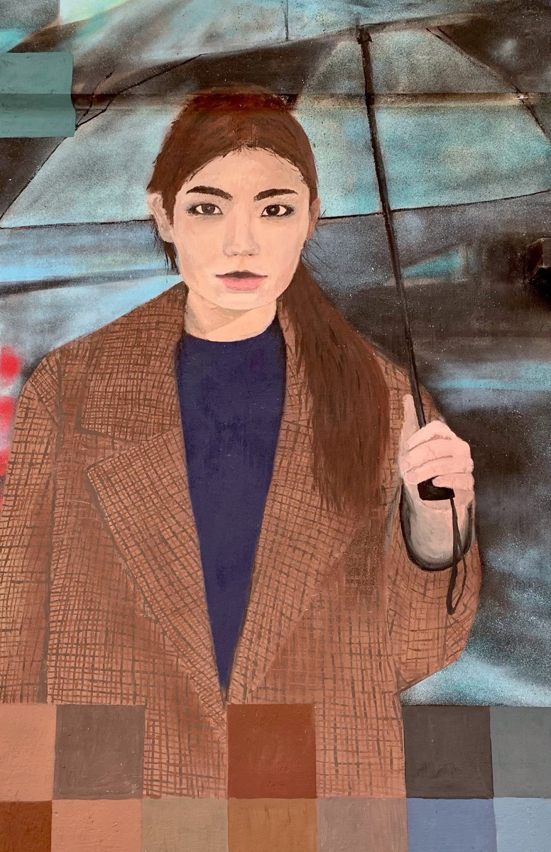 Известный во Владимире уличный художник Мишкин разукрасил серую стену постройки на территории популярного лофт-пространства. Так, на улице Сакко и Ванцетти появилось изображение девушки под зонтом. Что интересно, у нее есть реальный прототип.