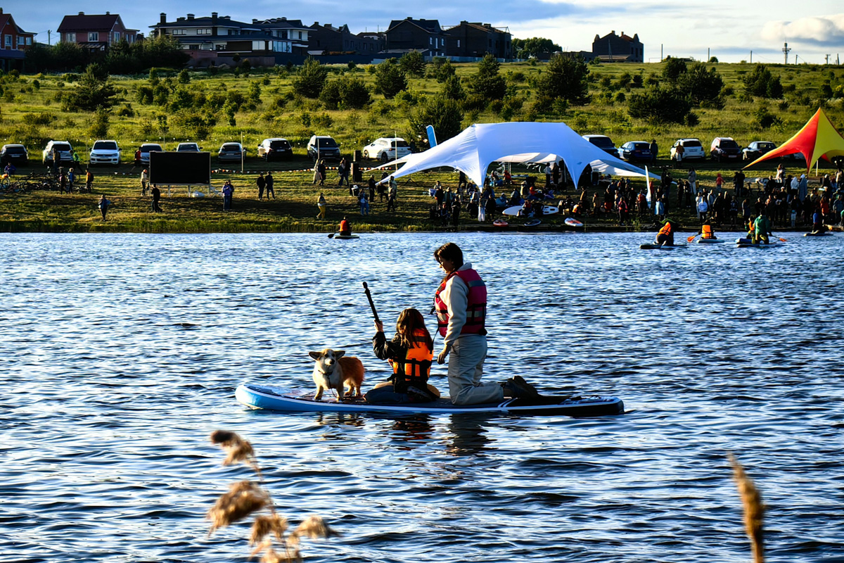 Маленькие владимирские пушистики породы корги и их хозяева продолжают собираться вместе, чтобы весело проводить время. Позади корги-маскарад, красная ковровая дорожка, дог своп-пати. Пришло время встать на доски, чтобы устроить летний массовый заплыв с четвероногими питомцами на sup-бордах!