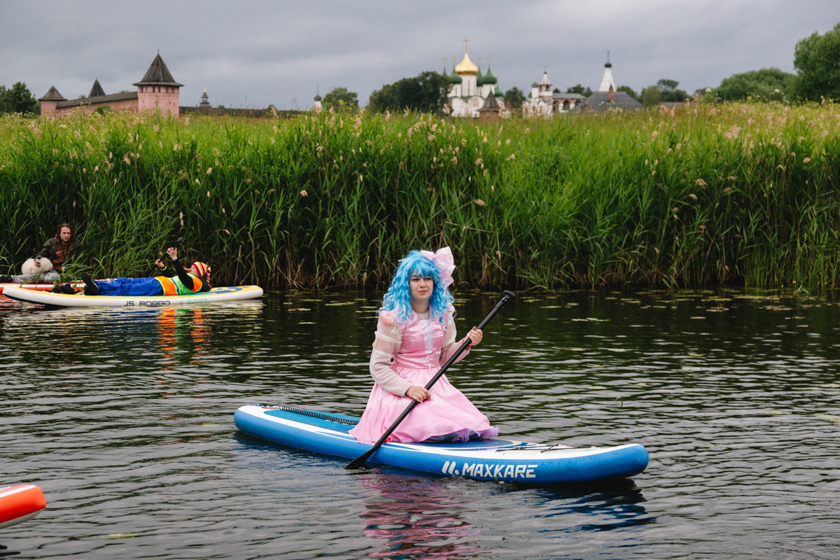 В минувшую субботу прошел второй в истории Суздаля карнавал на sup-бордах. Водный маршрут необычного фестиваля составил три километра по самому центру древнего города. Огромное количество знакомых героев из популярных сказок и культовых фильмов встали на доски и взяли в руки весла. Делимся подробностями этого неоспоримо яркого и зрелищного шоу.