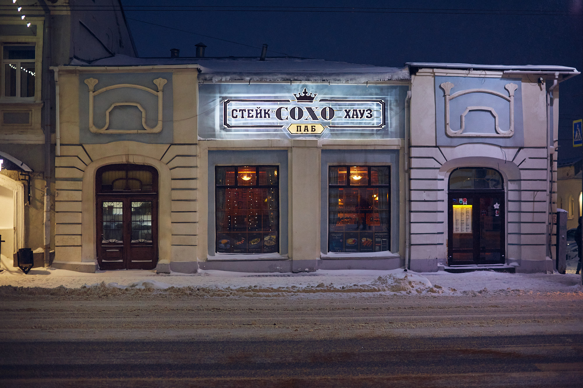 Этот дом во Владимире смотрит своим фасадом на улицу Большую Московскую, тем не менее адрес его: Девическая, 1. Сейчас все здание занимает ресторан «Сохо», позиционирующий себя как Steak House. Но начиналась его история с городской усадьбы, а продолжилась как доходный дом. Потом в нем был дореволюционный торговый центр, советский магазин и казино в лихие 90-е.