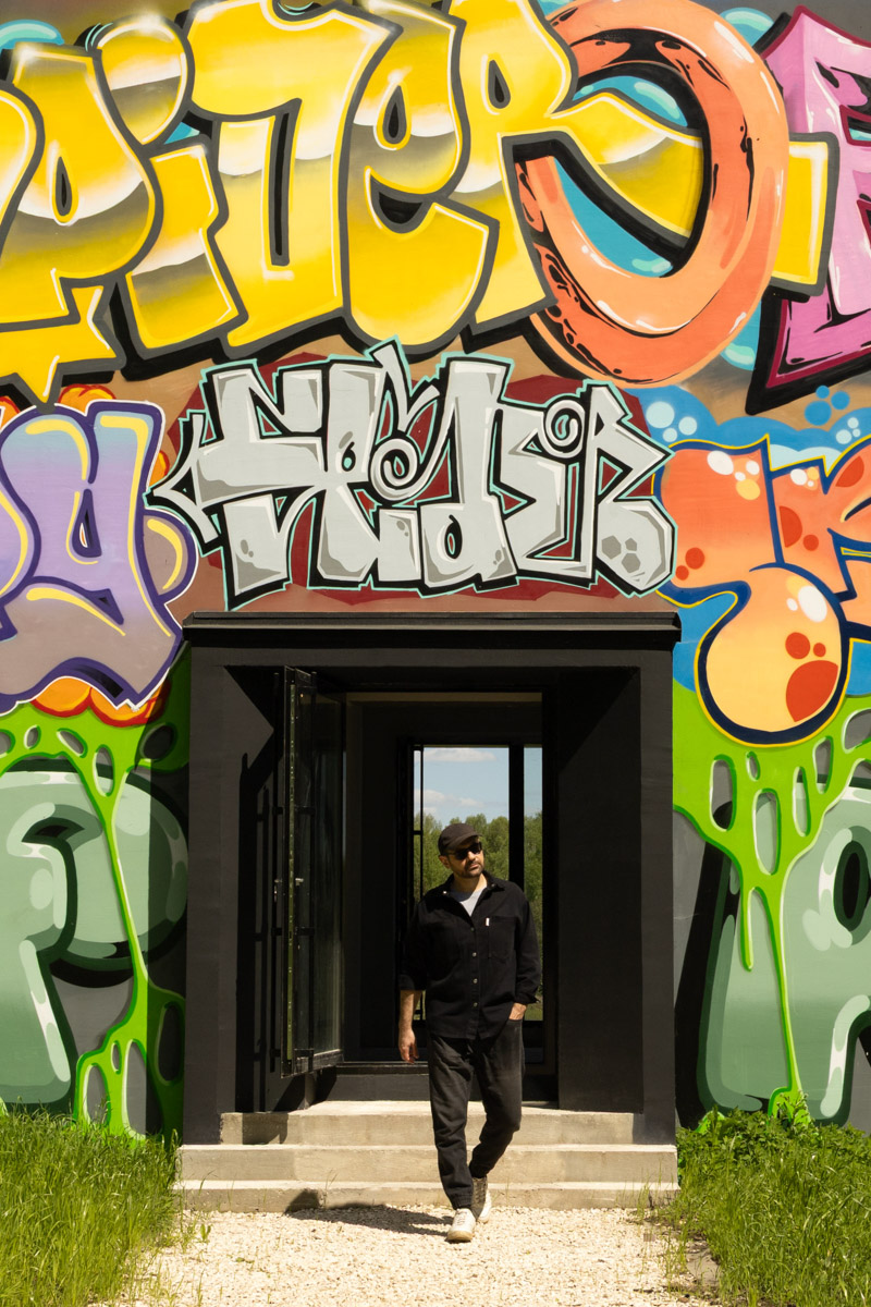 Яркий дом-куб, возведенный в нашем регионе на берегу реки, сразу же привлек внимание. Стены «Дома граффитчика» расписал известный райтер из Владимира — Спайдер. Собственно, для него весь проект и затевался. О новой арт-резиденции уличного художника «Ключ-Медиа» узнал из первых уст.